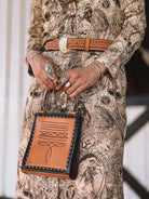 Thunderbird pendant chain necklace displayed on wooden slab with serape fabric underneath - The Wild J