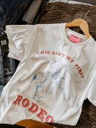 White t-shirt with red text and graphic of a bull on a hanger.