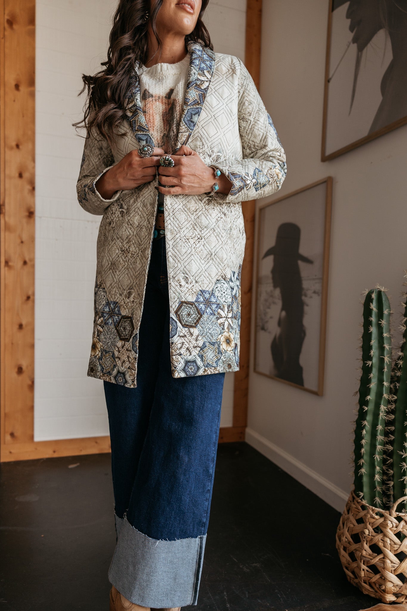 Woman modeling a western boho patchwork coat with wide-leg denim jeans and turquoise jewelry