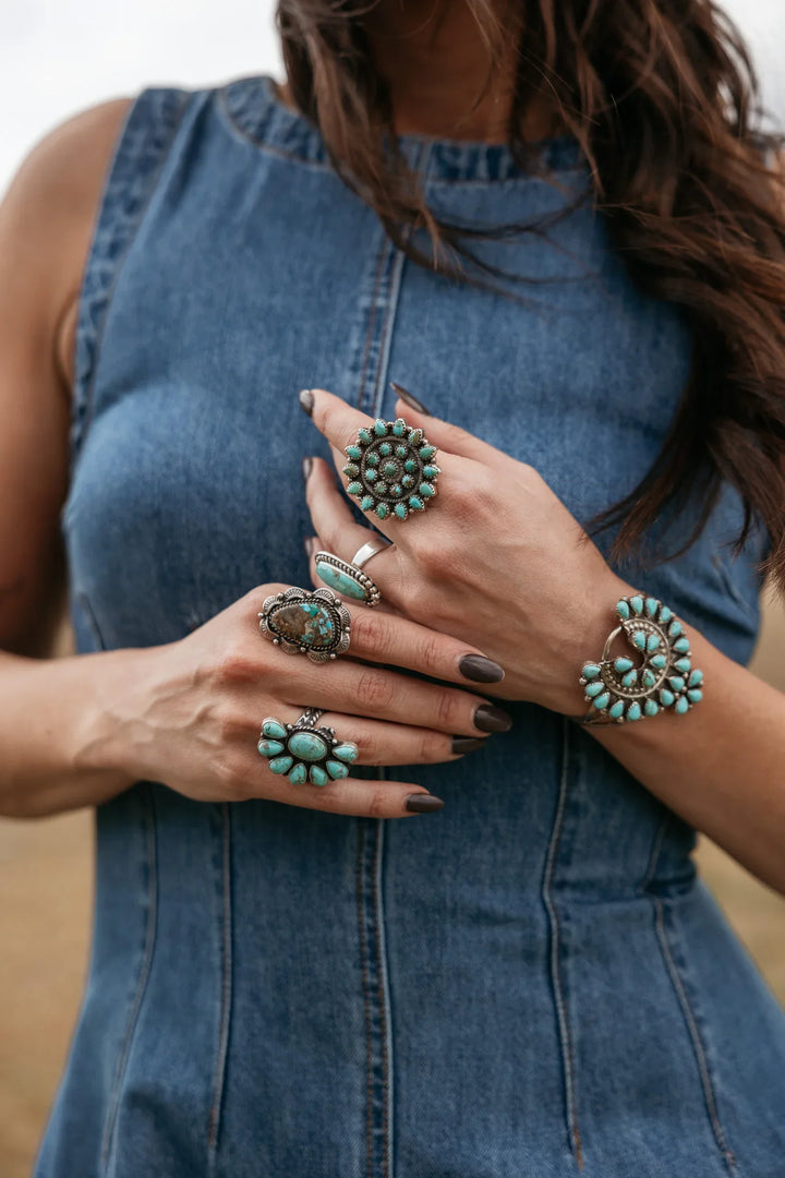 Woman in denim dress wearing western turquoise rings and boho jewelry