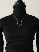 Thunderbird pendant chain necklace displayed on wooden slab with serape fabric underneath - The Wild J