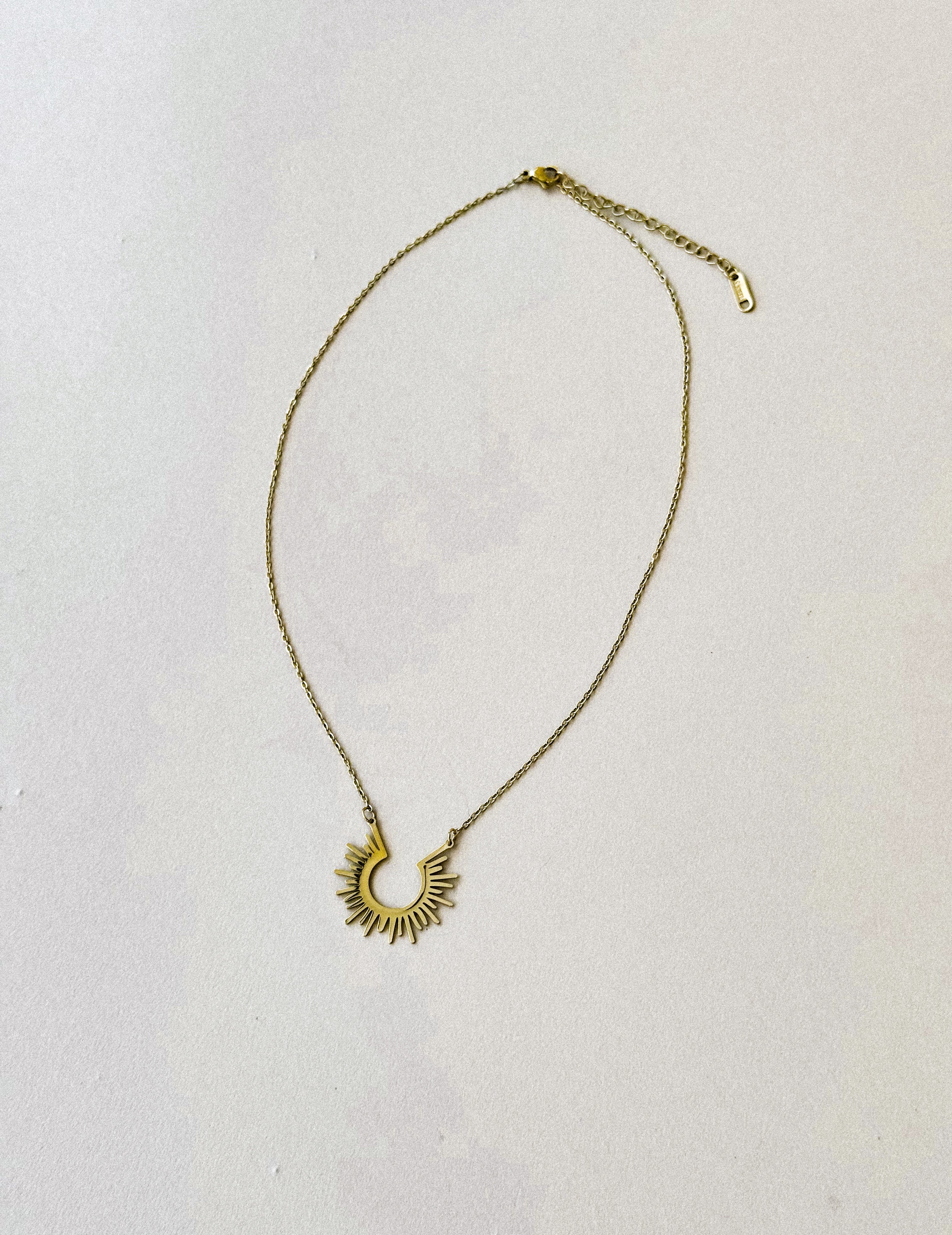 Thunderbird pendant chain necklace displayed on wooden slab with serape fabric underneath - The Wild J