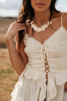 Thunderbird pendant chain necklace displayed on wooden slab with serape fabric underneath - The Wild J