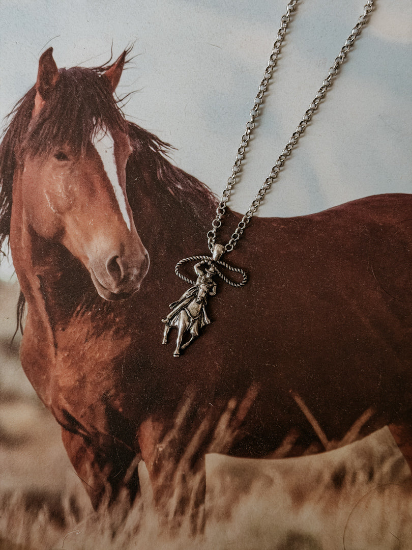 Western cowgirl pendant necklace displayed on background with brown horse, boho jewelry