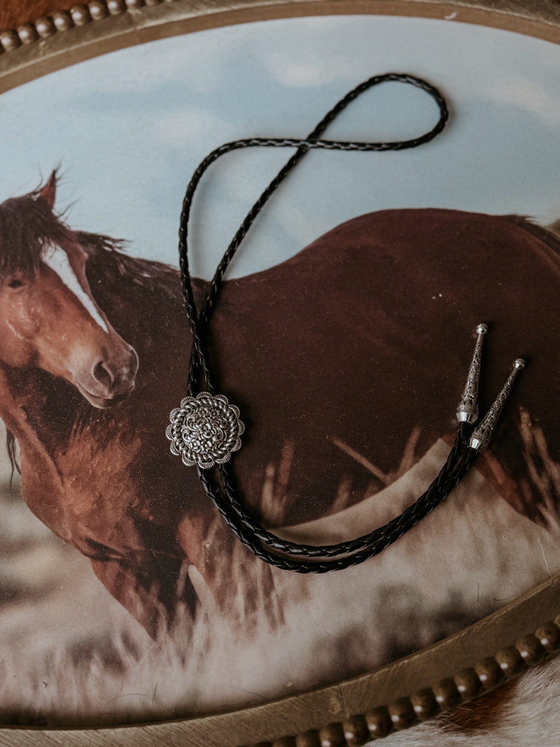 Thunderbird pendant chain necklace displayed on wooden slab with serape fabric underneath - The Wild J