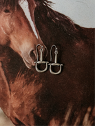 Silver western stirrup earrings on a horse background, cowgirl jewelry accessory