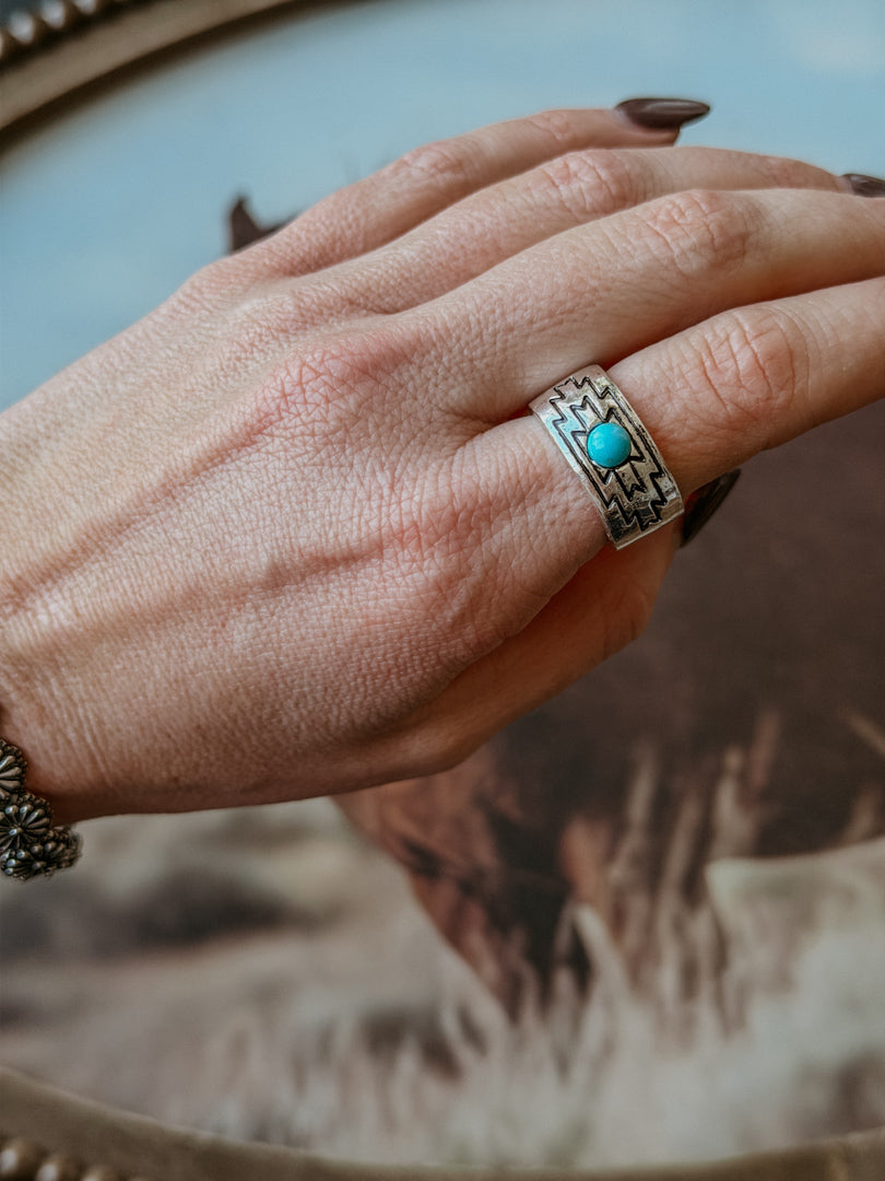 Hand wearing a silver southwestern turquoise ring, boho western jewelry style