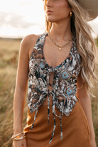 women wearing tie front halter top with western pattern and a camel skirt standing in a field. 