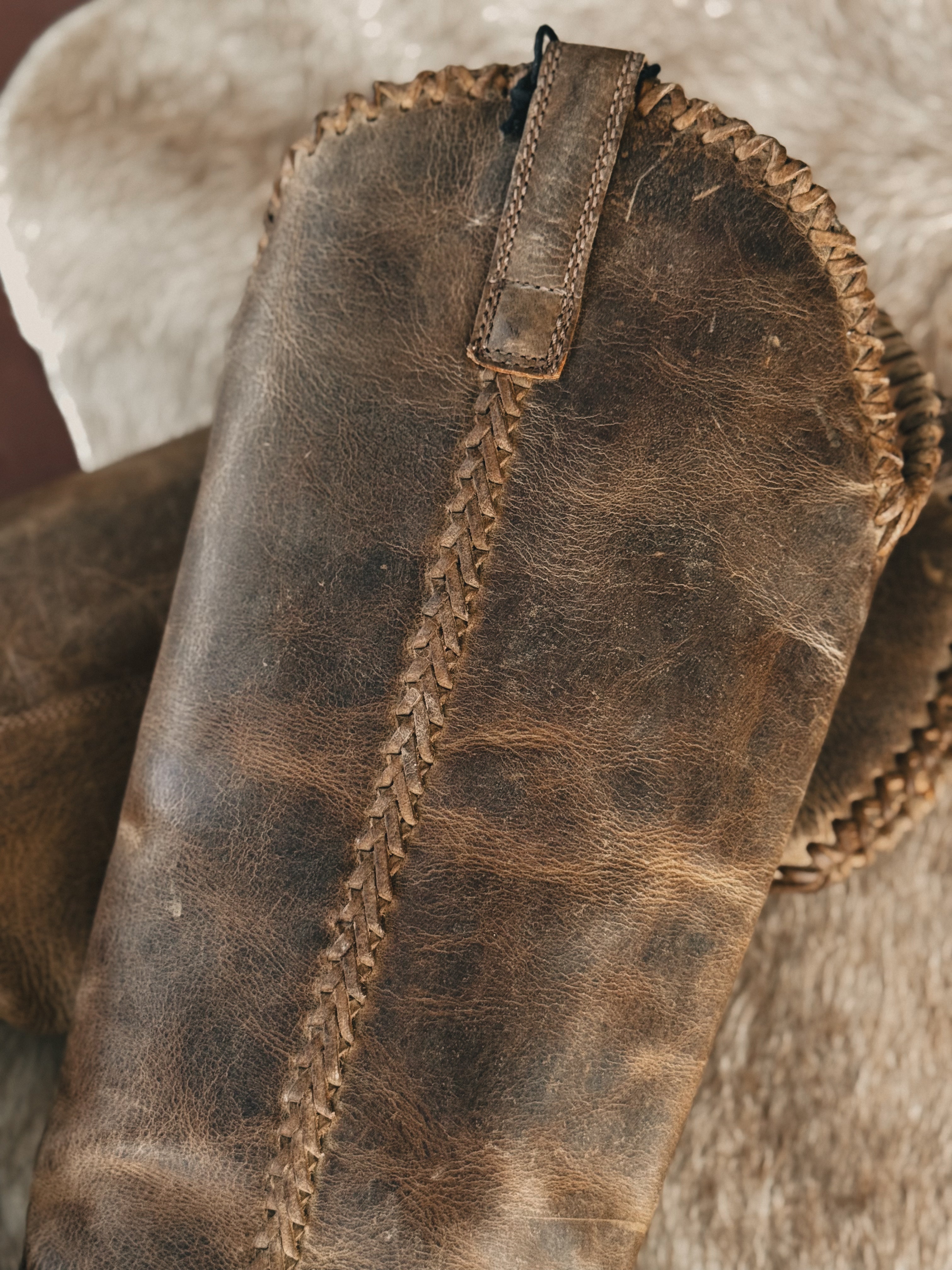 Thunderbird pendant chain necklace displayed on wooden slab with serape fabric underneath - The Wild J
