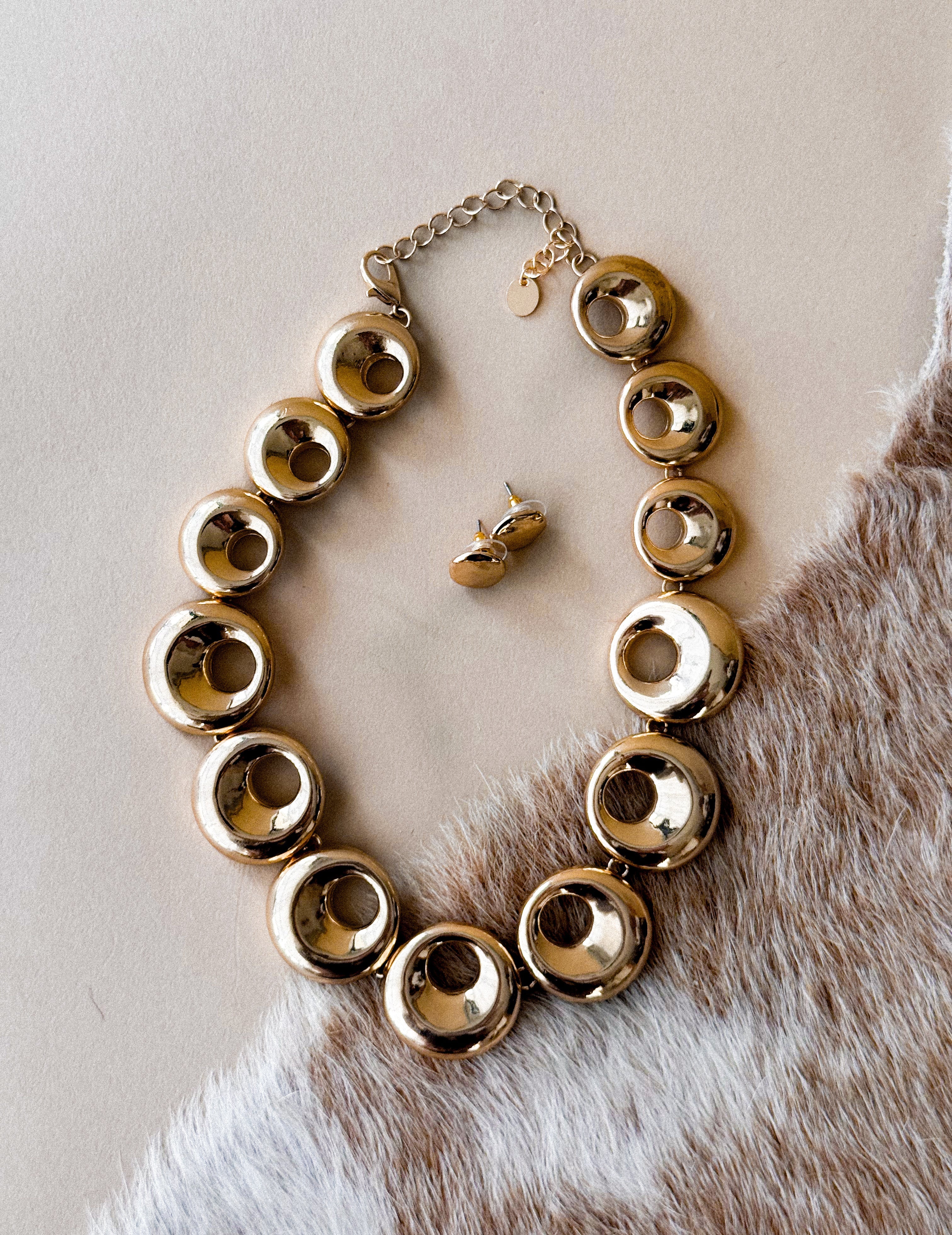 Thunderbird pendant chain necklace displayed on wooden slab with serape fabric underneath - The Wild J