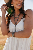 Thunderbird pendant chain necklace displayed on wooden slab with serape fabric underneath - The Wild J