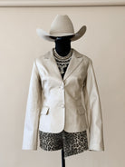 Western boho outfit with beige cowboy hat, cream blazer, leopard print shorts, layered necklaces