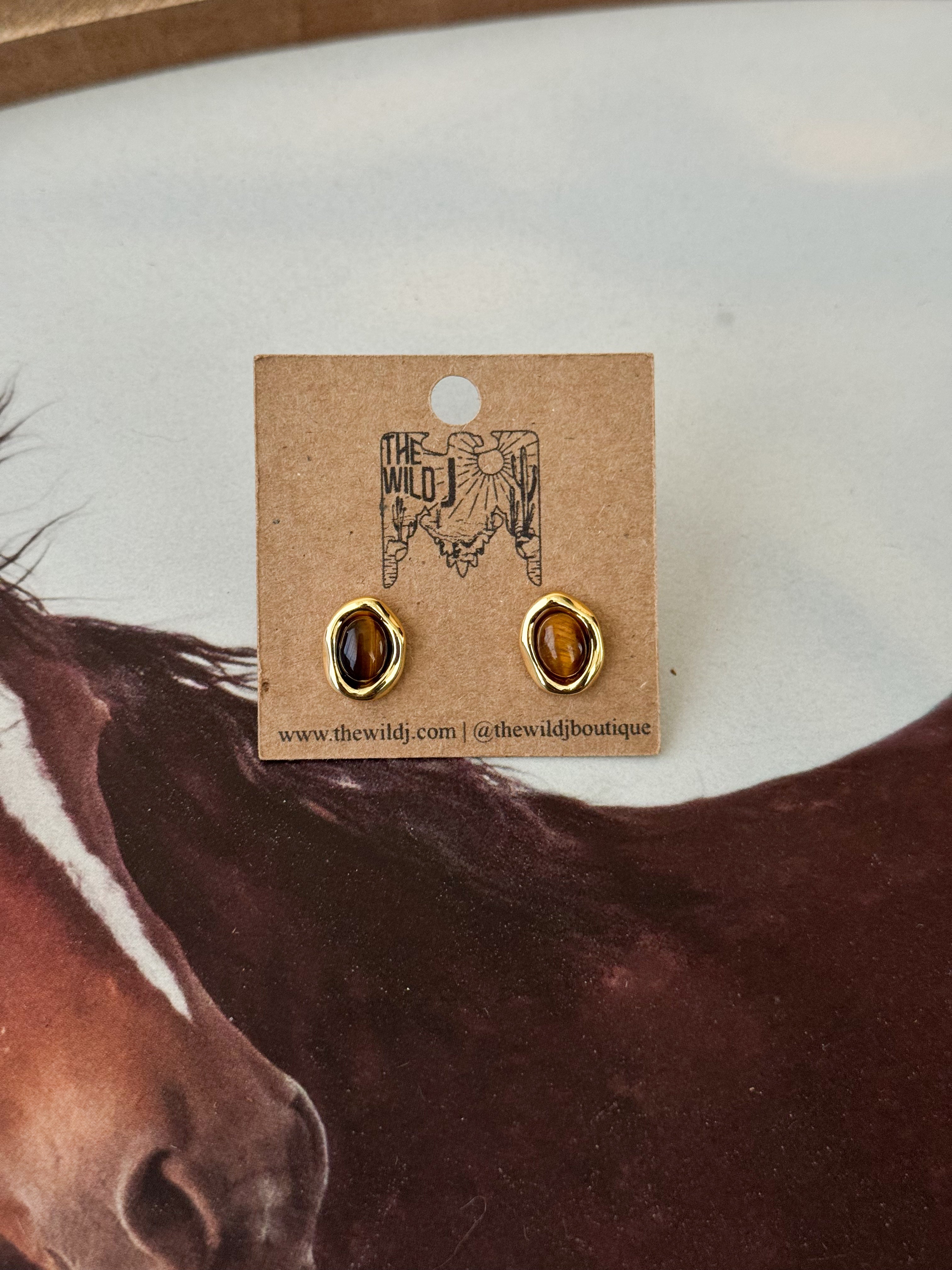 Thunderbird pendant chain necklace displayed on wooden slab with serape fabric underneath - The Wild J