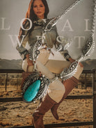 Western boho turquoise necklace and earrings with feather details, styled on cowgirl fashion magazine.