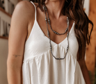 Woman in white boho dress wearing layered western silver bead necklaces