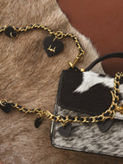 Thunderbird pendant chain necklace displayed on wooden slab with serape fabric underneath - The Wild J