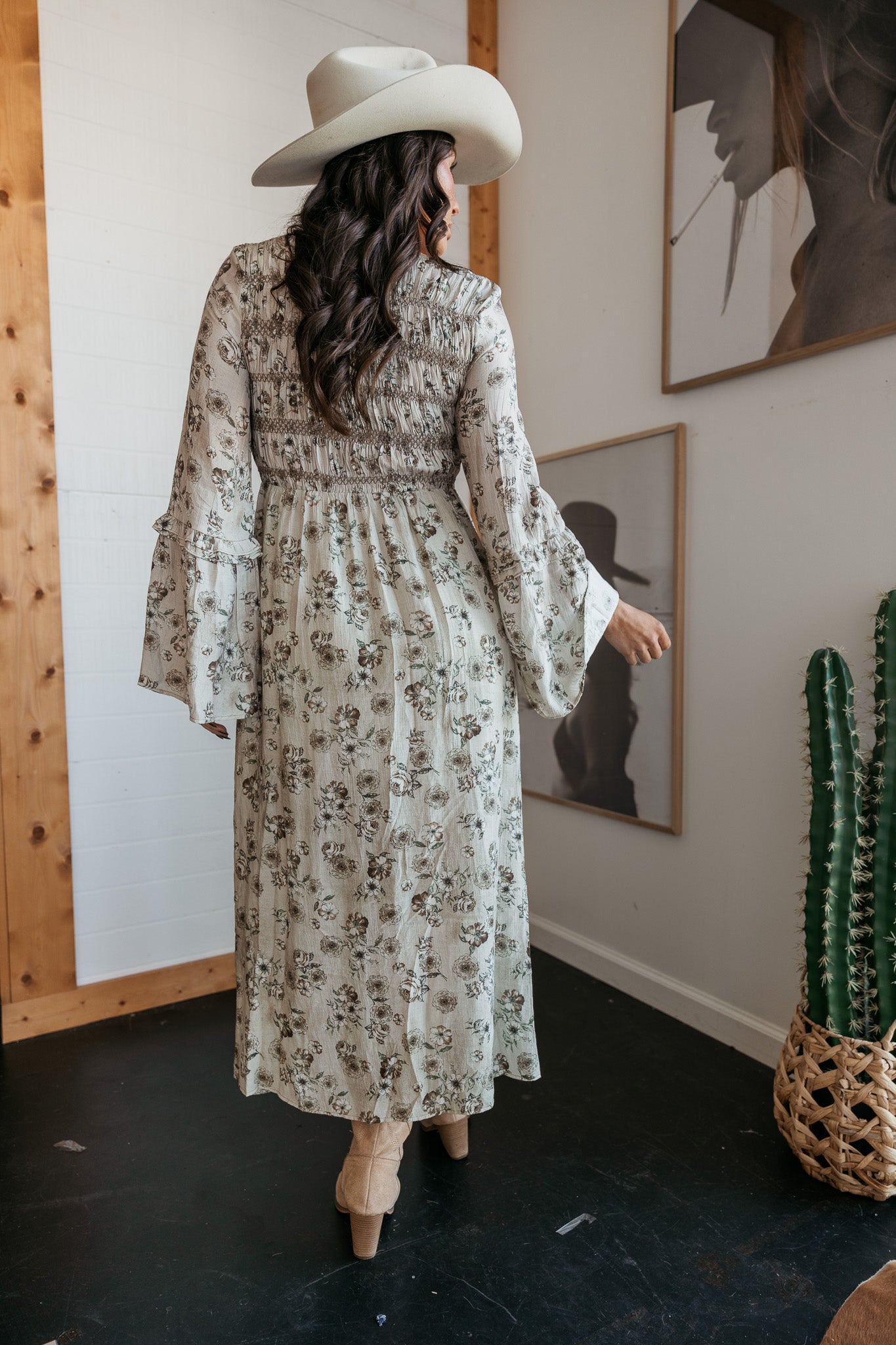 western boho dress in white with sage floral print with a slit and beige knee-high cowgirl boots back view