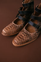 Thunderbird pendant chain necklace displayed on wooden slab with serape fabric underneath - The Wild J