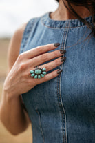 Woman wearing a turquoise western ring with denim sleeveless dress, boho cowgirl style