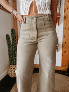 High-waisted khaki wide-leg jeans with front patch pockets and white lace crop top in boho western style