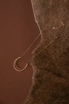 Thunderbird pendant chain necklace displayed on wooden slab with serape fabric underneath - The Wild J