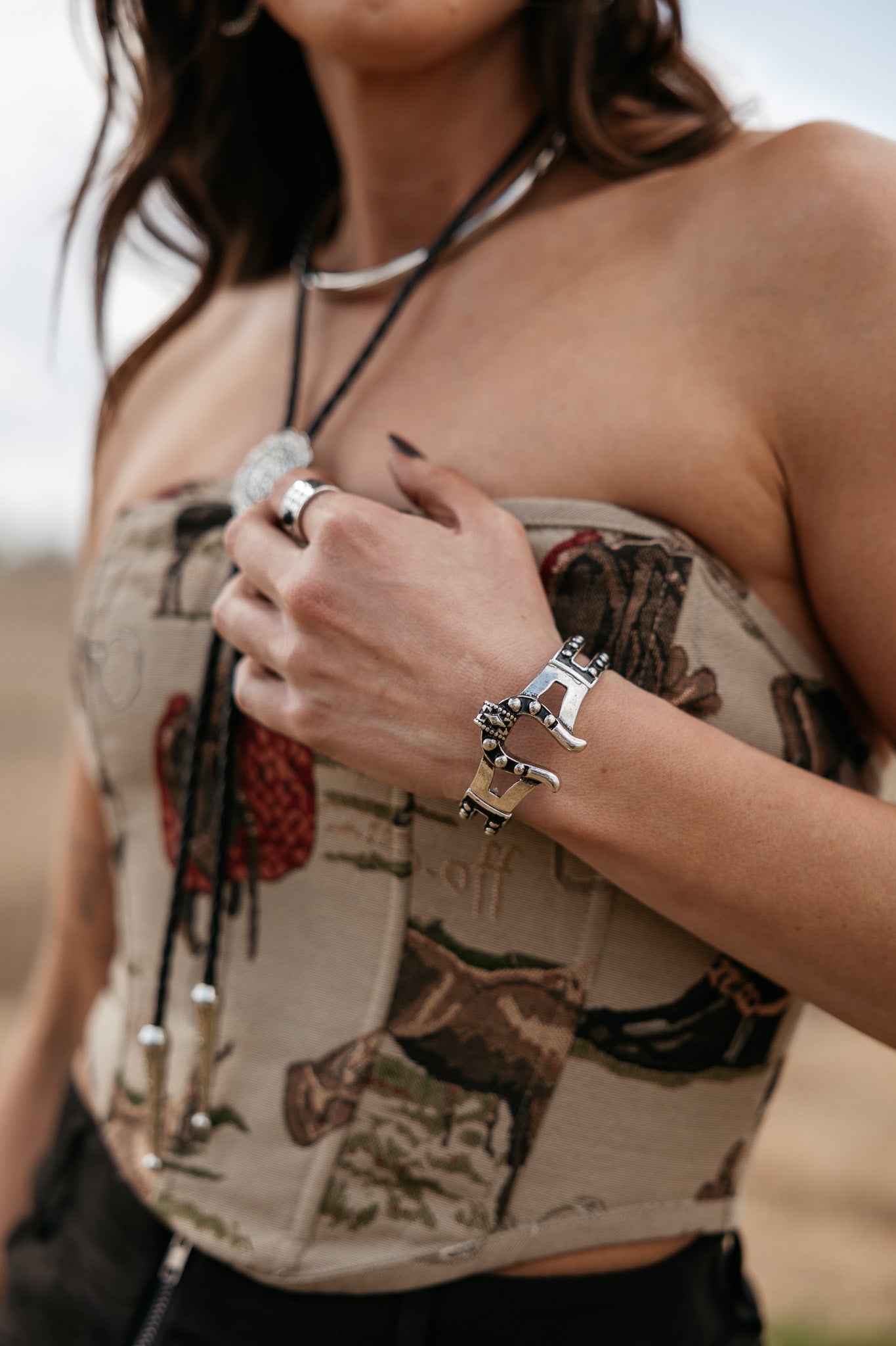 Woman wearing western boho corset top with cowgirl jewelry and silver rodeo bracelet