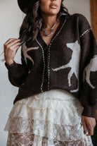 Woman in western horse print sweater, layered lace skirt, and silver statement necklace