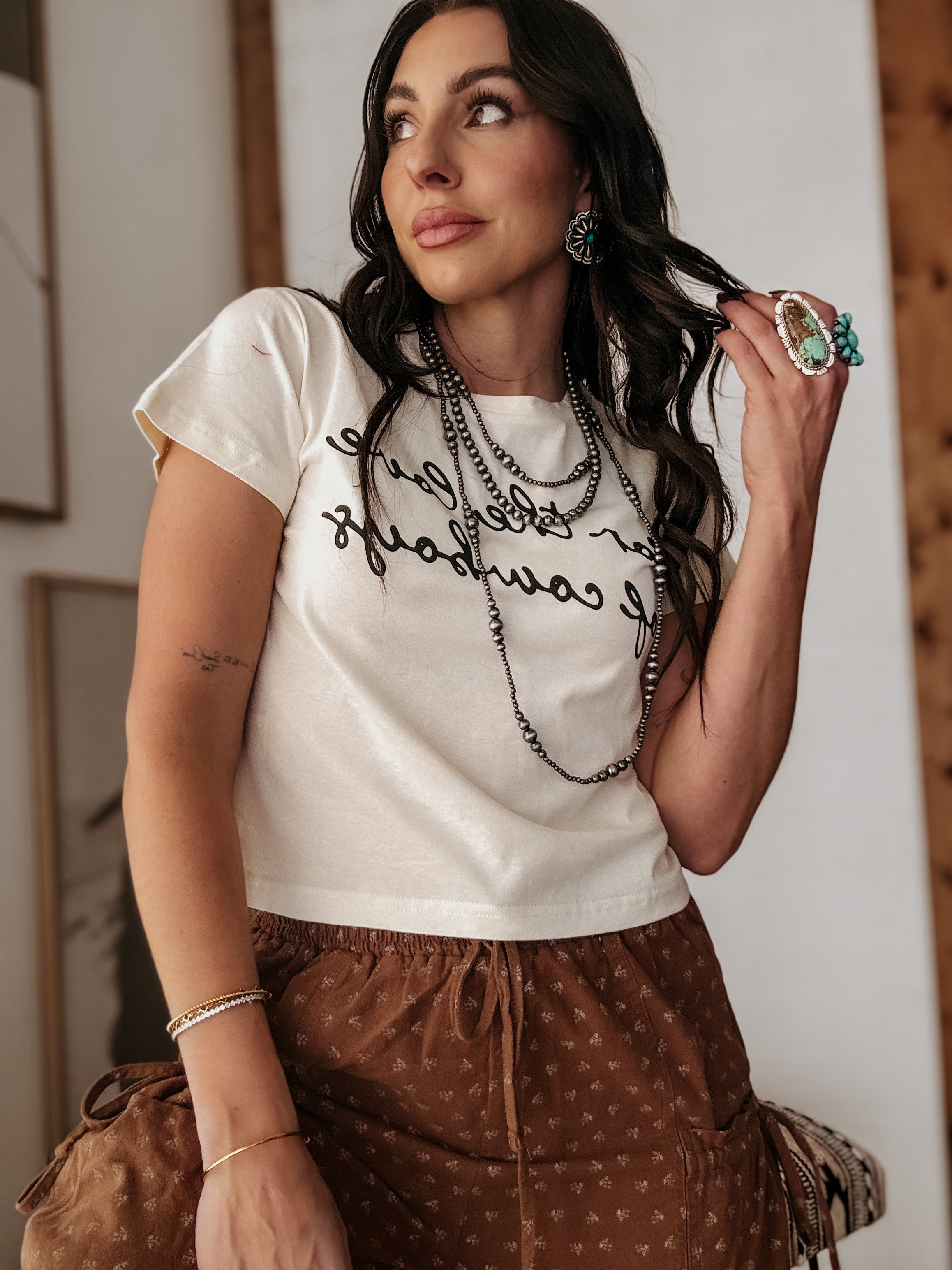 Thunderbird pendant chain necklace displayed on wooden slab with serape fabric underneath - The Wild J