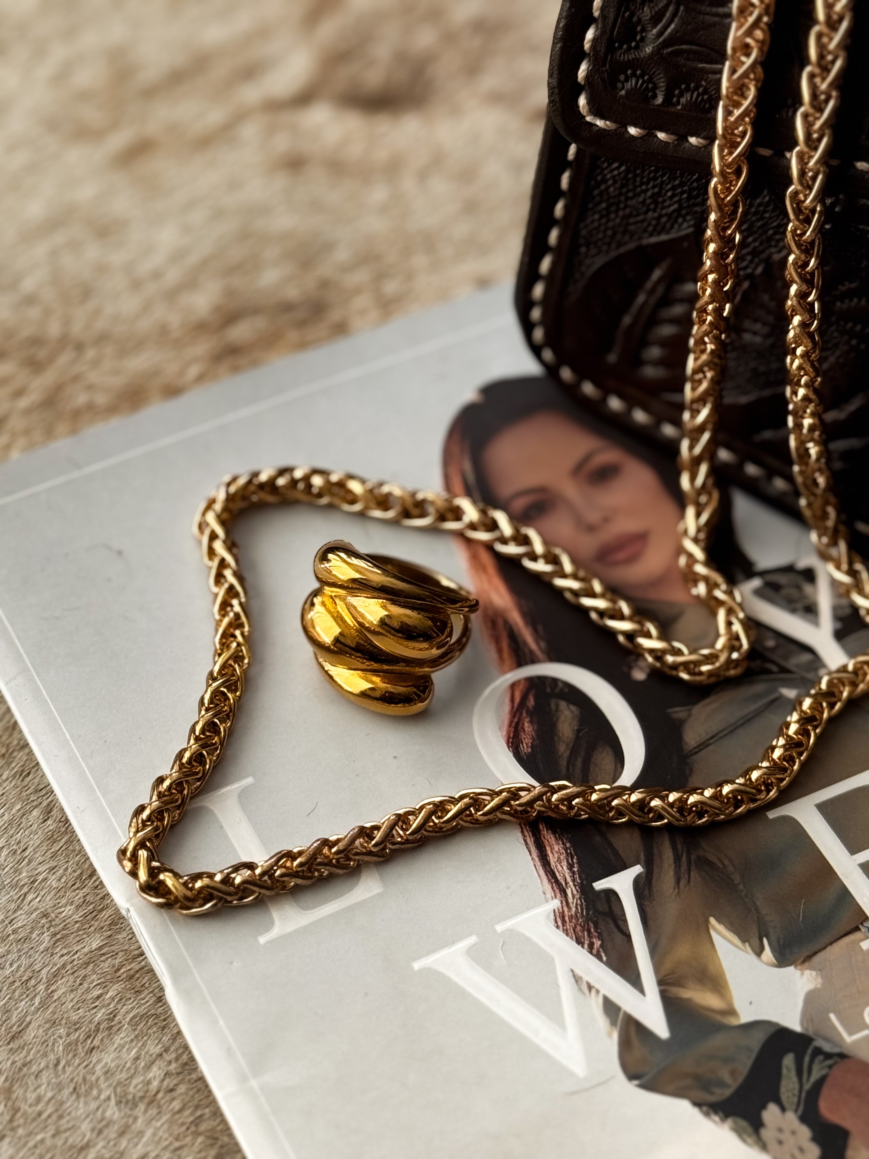 Thunderbird pendant chain necklace displayed on wooden slab with serape fabric underneath - The Wild J