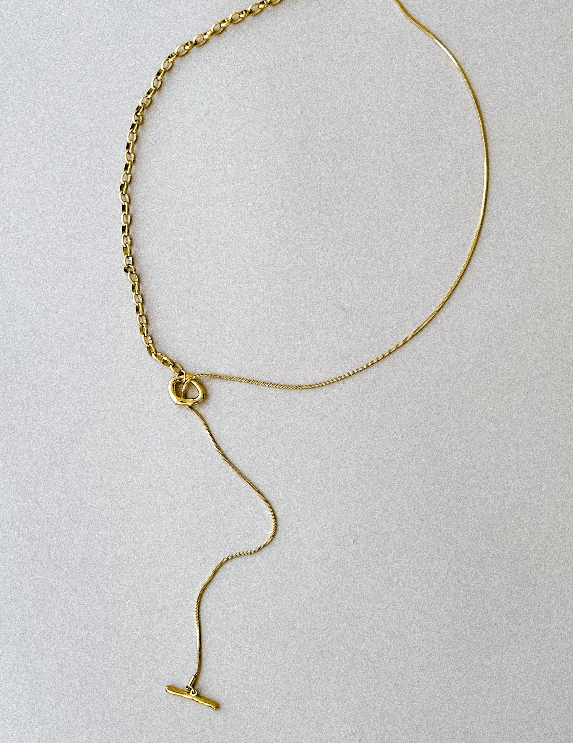 Thunderbird pendant chain necklace displayed on wooden slab with serape fabric underneath - The Wild J