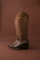 brown suede western cowboy boots with embroidery on brown background