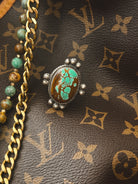 Thunderbird pendant chain necklace displayed on wooden slab with serape fabric underneath - The Wild J