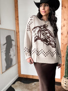 Woman in cowgirl hat wearing western boho sweater and brown skirt, western boutique style
