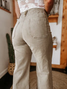 High-waisted western flare jeans styled with a lace top, boho boutique background