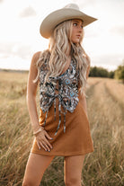 women wearing tie front halter top with western pattern and a camel skirt standing in a field. 