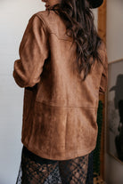 Woman wearing a brown suede western jacket and black lace skirt, boho cowgirl style