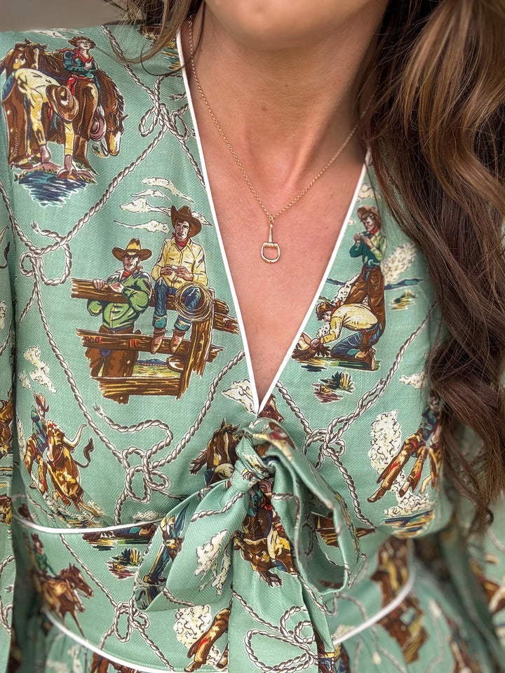 Western boho dress with cowboy print, deep V-neckline, and gold stirrup necklace