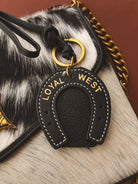 Thunderbird pendant chain necklace displayed on wooden slab with serape fabric underneath - The Wild J