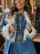 Woman in western boho denim dress with faux fur trim, turquoise jewelry, and concho belt