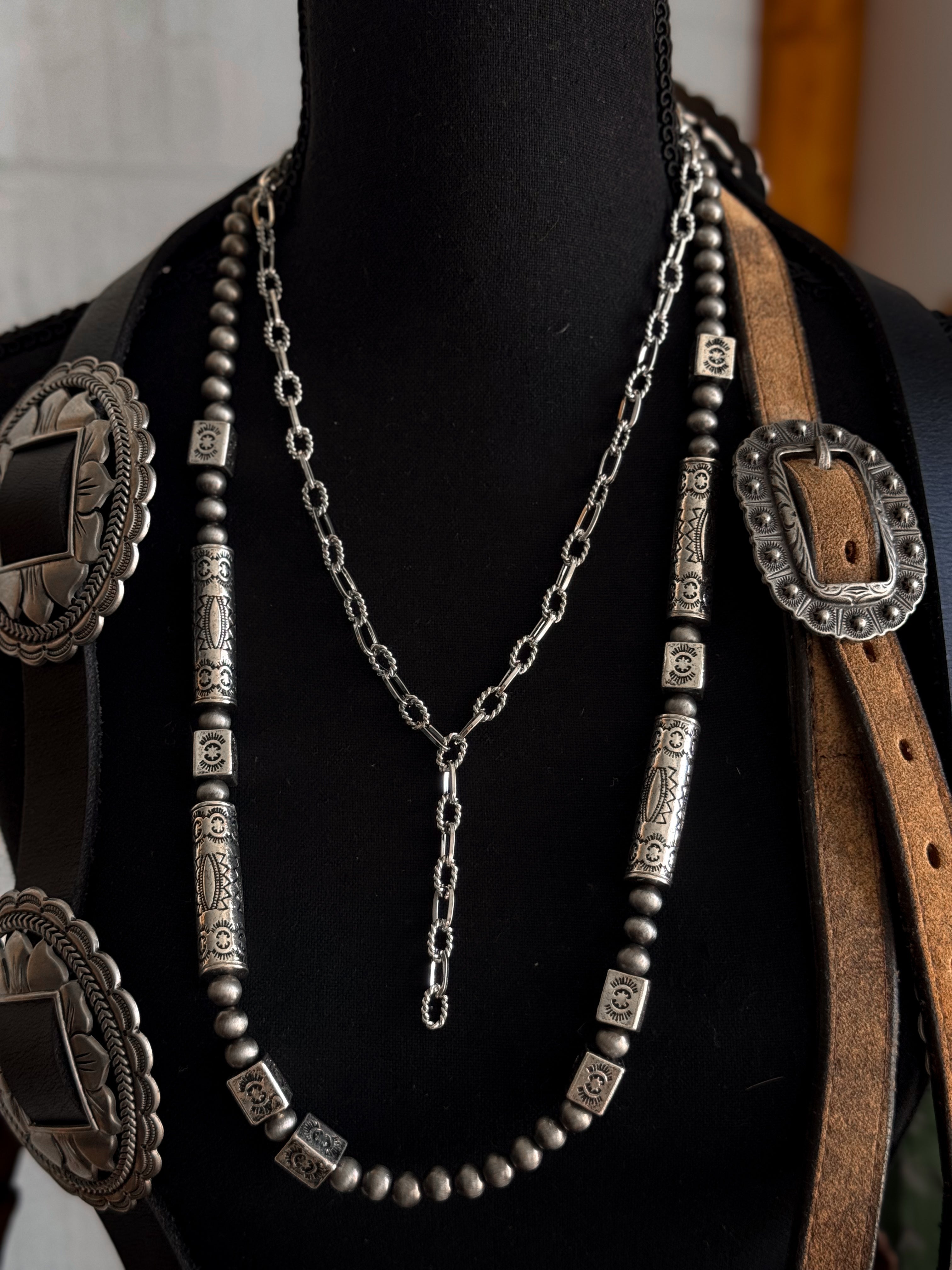 Thunderbird pendant chain necklace displayed on wooden slab with serape fabric underneath - The Wild J