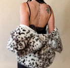 Woman in black lace western dress with animal print faux fur shawl, back tattoo visible