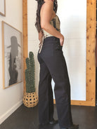 Woman in high-waisted black western flare jeans and cowboy hat, boho boutique style