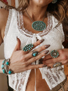 Woman wearing western boho turquoise jewelry set with lace top, rings, necklace, and bracelets