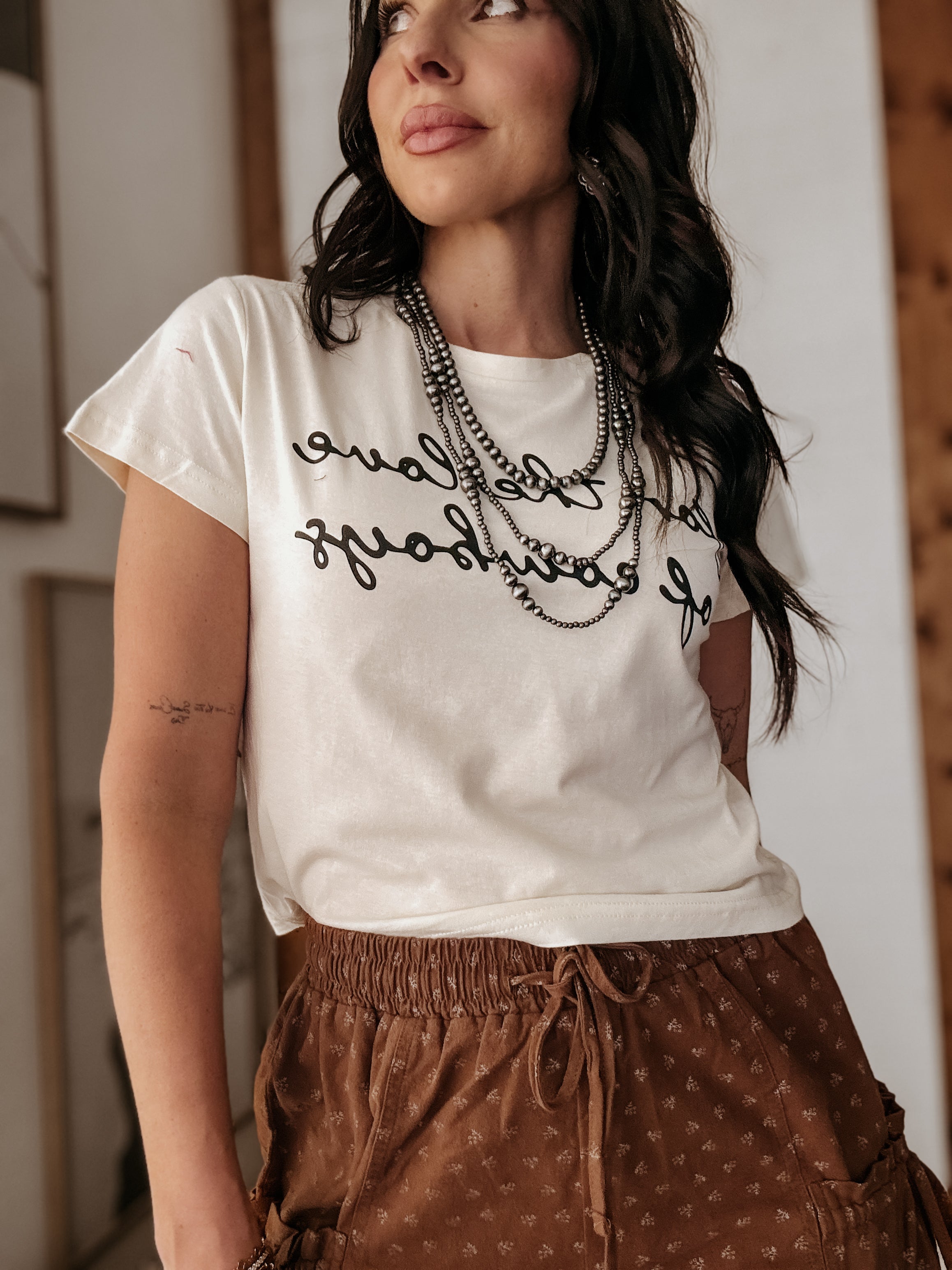 Thunderbird pendant chain necklace displayed on wooden slab with serape fabric underneath - The Wild J