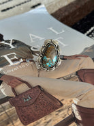 Western boho turquoise statement ring with engraved silver setting on magazine background