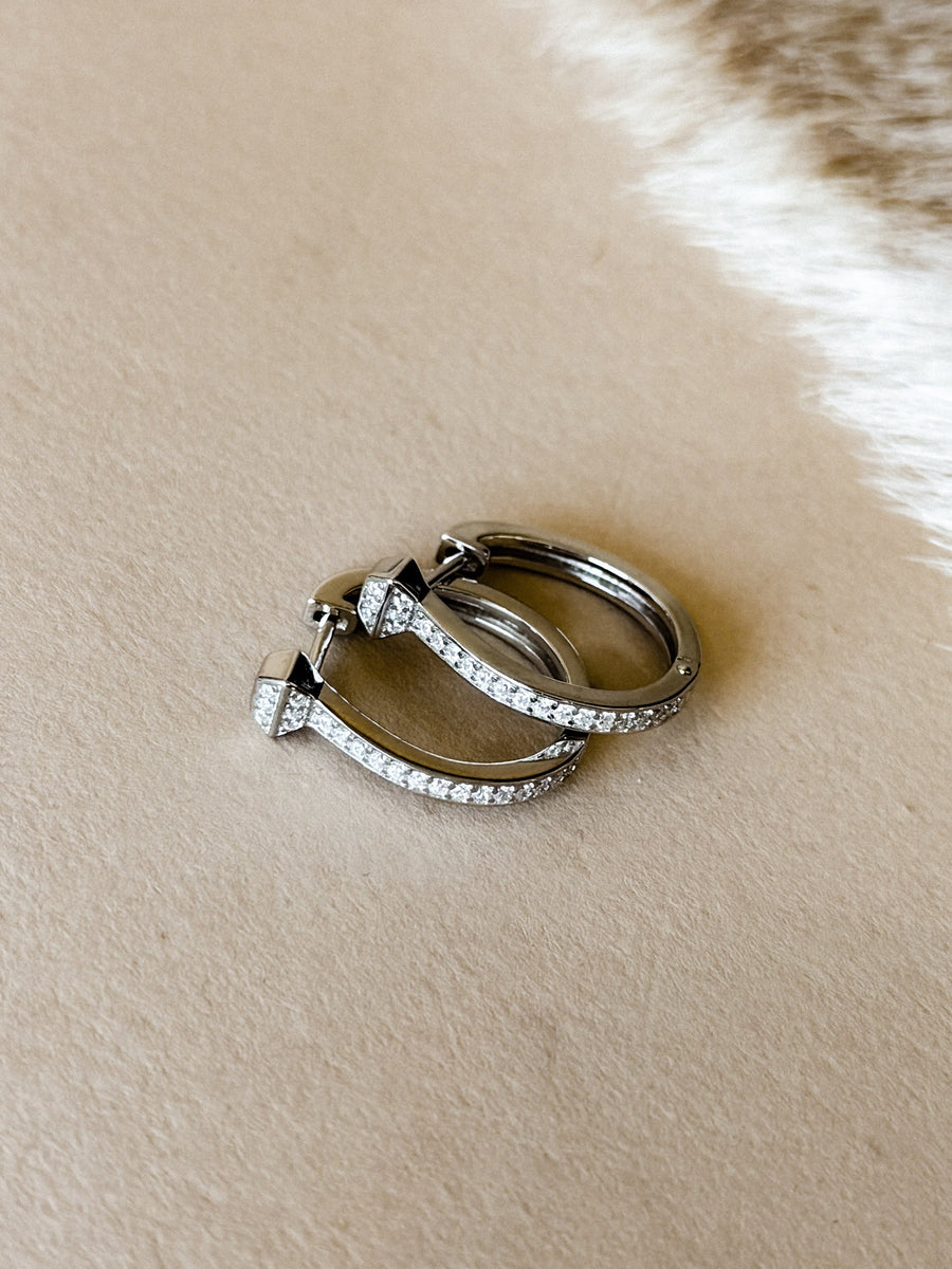 Sterling silver hinged hoop earrings with cubic zirconia accents.