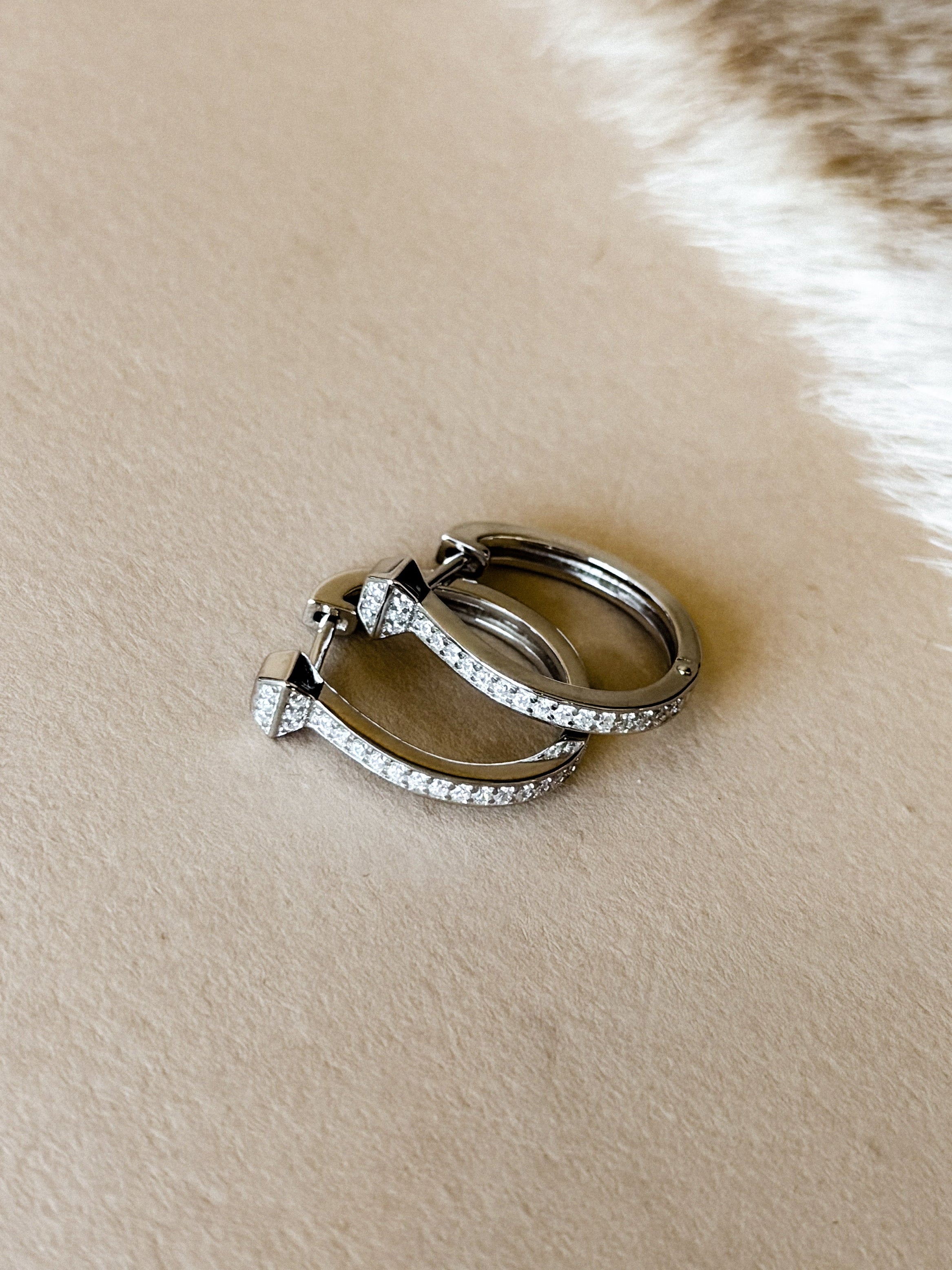 Sterling silver hinged hoop earrings with cubic zirconia accents.