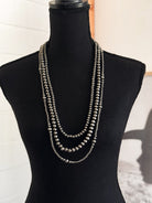 Thunderbird pendant chain necklace displayed on wooden slab with serape fabric underneath - The Wild J