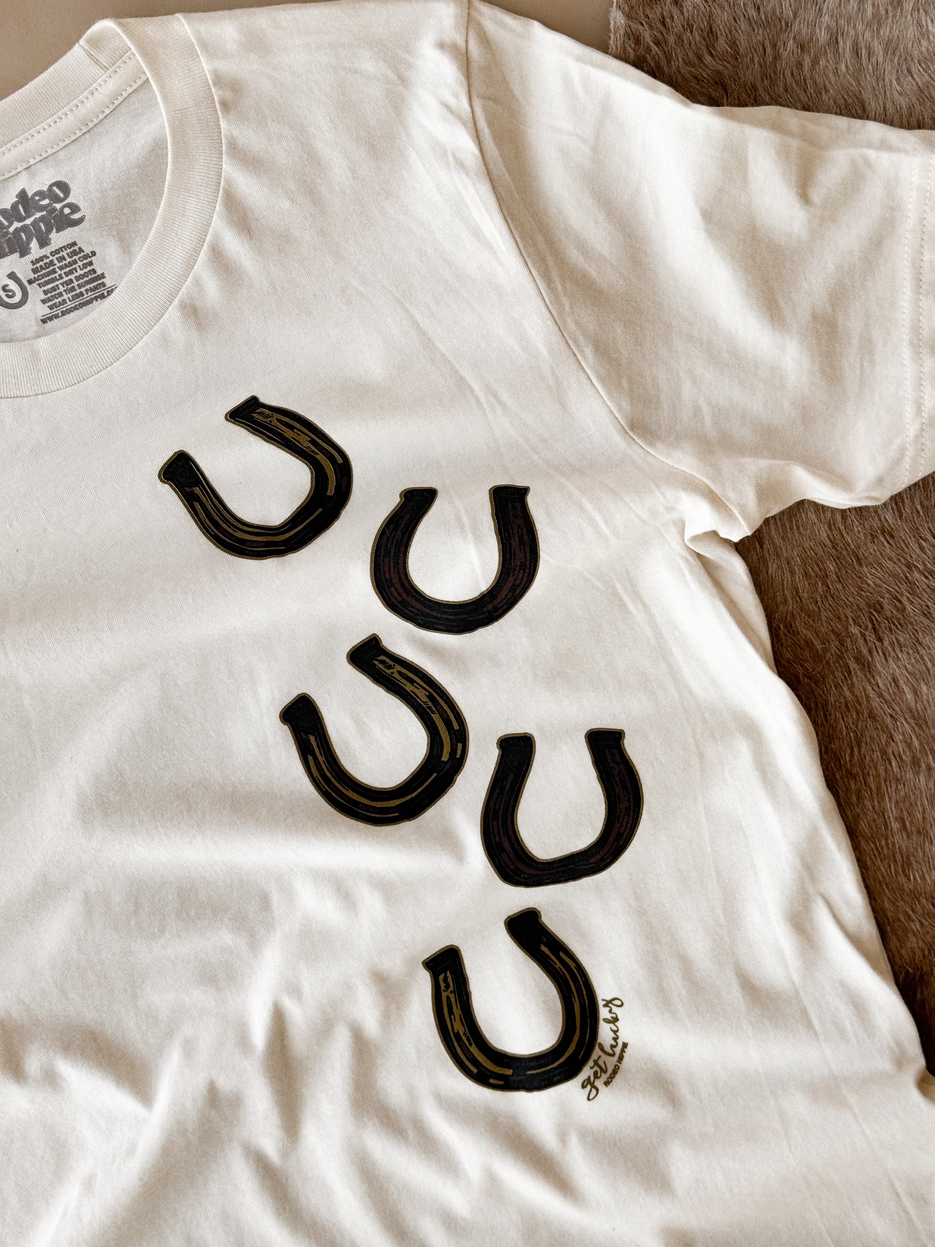 White western graphic t-shirt with black horseshoe prints, boho cowgirl outfit style