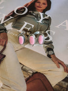 Western pink stone statement ring trio on cowgirl fashion magazine with embroidered shirt and white pants